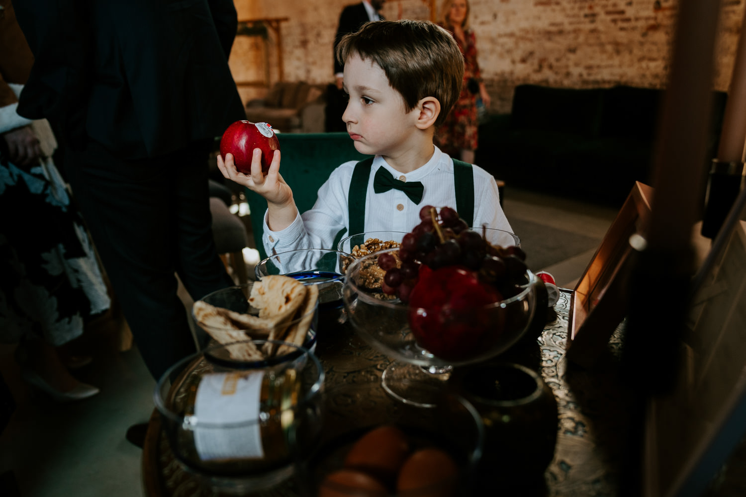 wedding photograph of a boy looking at an apple 